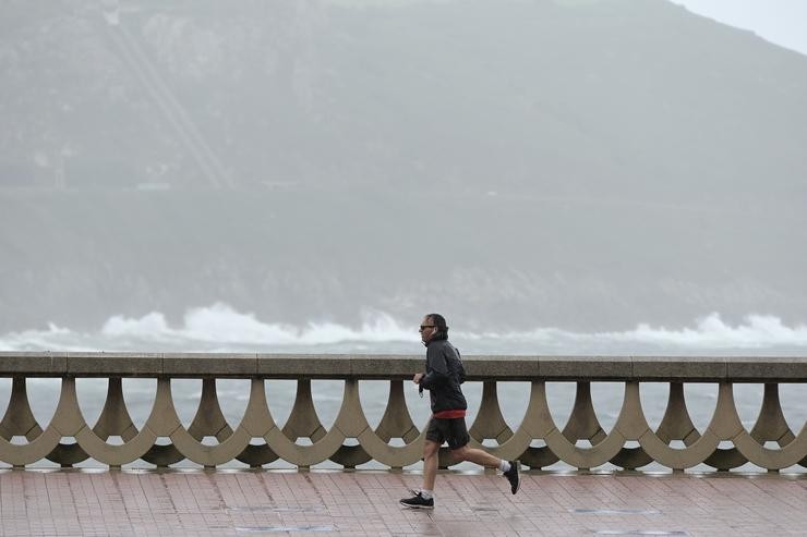Un home, con chubasqueiro, corre polo Paseo Marítimo da Coruña. / M. Dylan / Europa Press