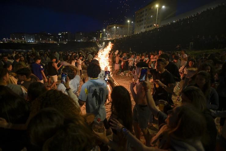 Centenares de persoas fronte a unha fogueira na Noite de San Xoán, a 23 de xuño de 2022, na Coruña / M. Dylan - Europa Press / Europa Press