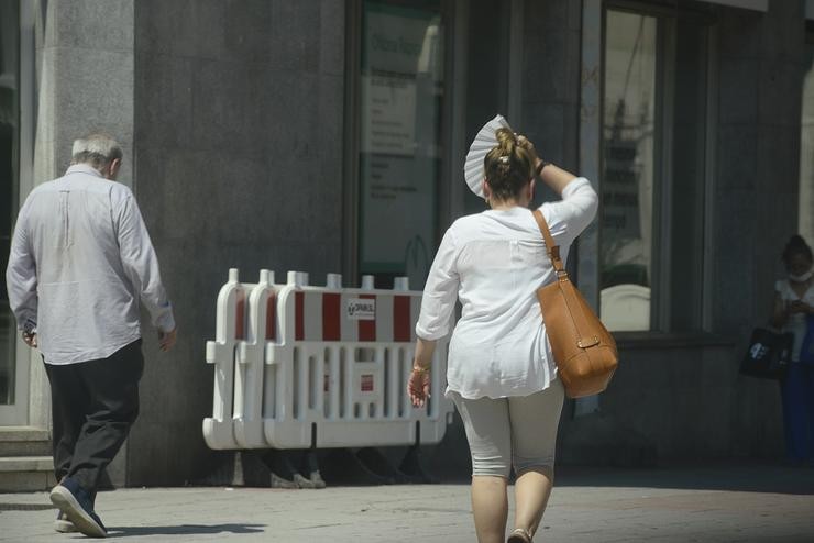 Dúas persoas camiñan por unha vía en plena onda de calor, a 12 de xullo de 2022, en Ourense, Galicia (España).. Rosa Veiga - Europa Press 