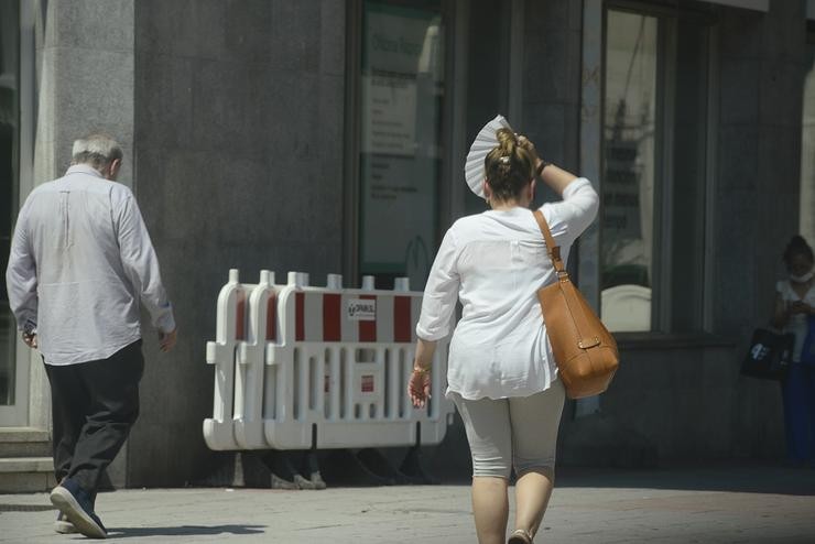 Dúas persoas camiñan por unha vía en plena onda de calor, a 12 de xullo de 2022, en Ourense. Rosa Veiga - Europa Press