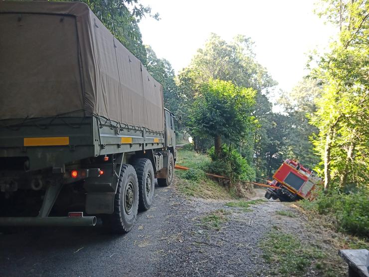 Dous camións do exército impiden circular por varios camiños para atallar os lumes. Un deles está envorcado 