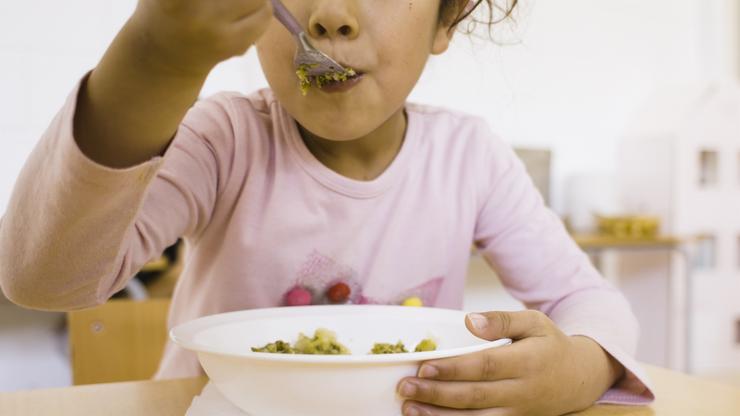Nena comendo no comedor escolar / EDUCO-PERE GIBERT - Arquivo