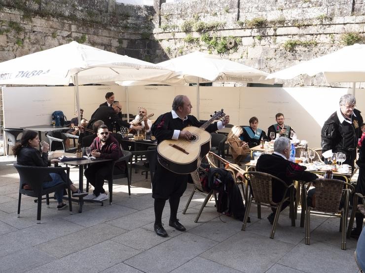 Un tuno afina un instrumento na terraza dun bar en Santiago de Compostela, a 9 de outubro de 2021 / César Arxina - Arquivo