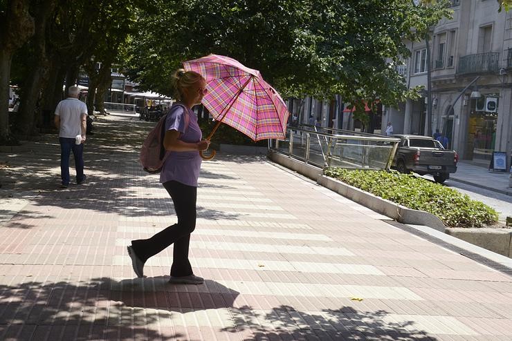 Unha muller camiña por unha vía en plena onda de calor 