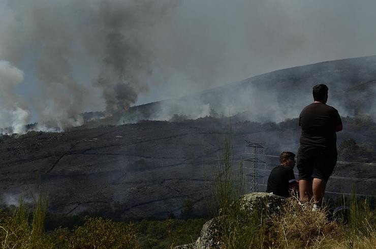 Dúas persoas de Grou observan o incendio forestal na Serra do Leboreiro, en Senderiz, no parque natural de Baixa Limia e Serra do Xurés 