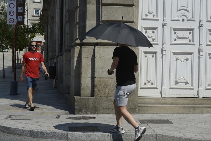 Dúas persoas camiñan por unha vía en plena onda de calor, a 12 de xullo de 2022, en Ourense, Galicia (España). Os termómetros da práctica totalidade do territorio galego alcanzarán valores ?extremos? debido á onda de calor que comezou a semana pasada. Rosa Veiga - Europa Press 