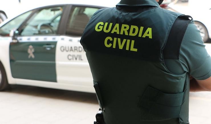  Un axente da Garda Civil, de costas, xunto a un vehículo oficial / Garda Civil