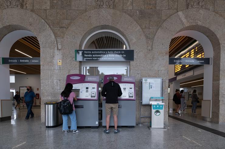 Dúas persoas compran billetes nos caixeiros de venda automática na estación de trens / César Argina - Europa Press / Europa Press