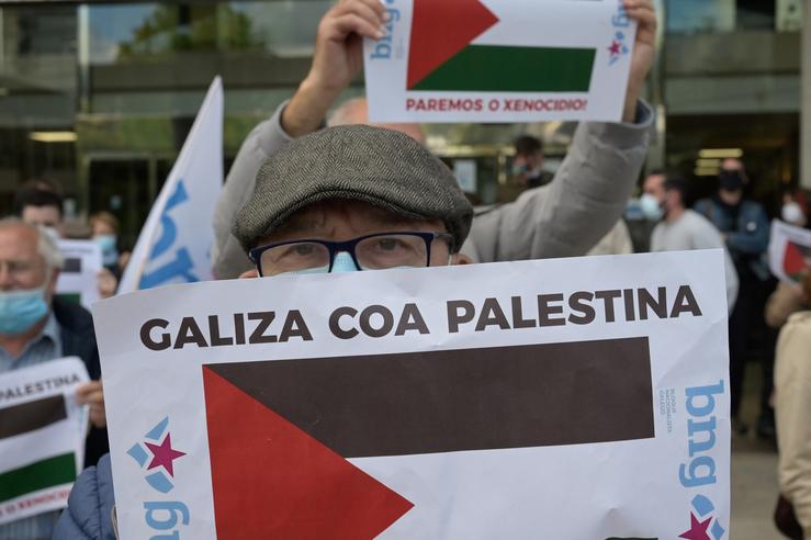 Un home sostén un cartel durante unha concentración en solidariedade con Palestina 