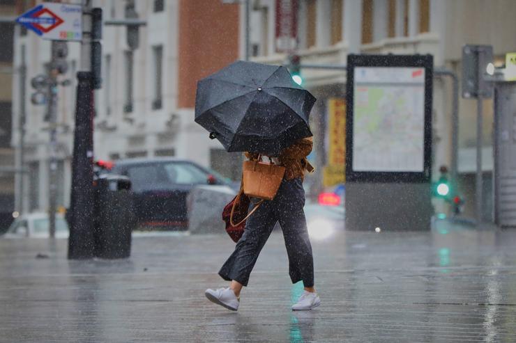 Arquivo - Unha persoa camiña polo centro da capital nunha xornada marcada polas choivas e a baixada de temperaturas, en Madrid, (España).. Jesús Hellín - Europa Press - Arquivo