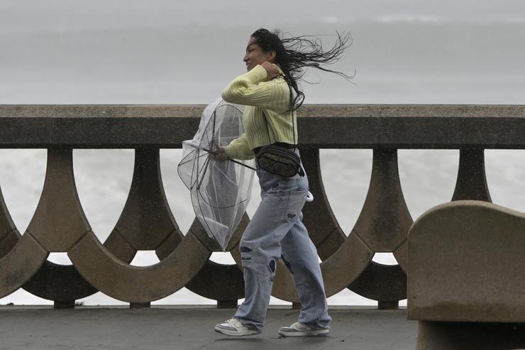 Unha persoa protéxese da choiva e o vento cun paraugas, a 20 de outubro de 2023, na Coruña / M. Dylan - Arquivo