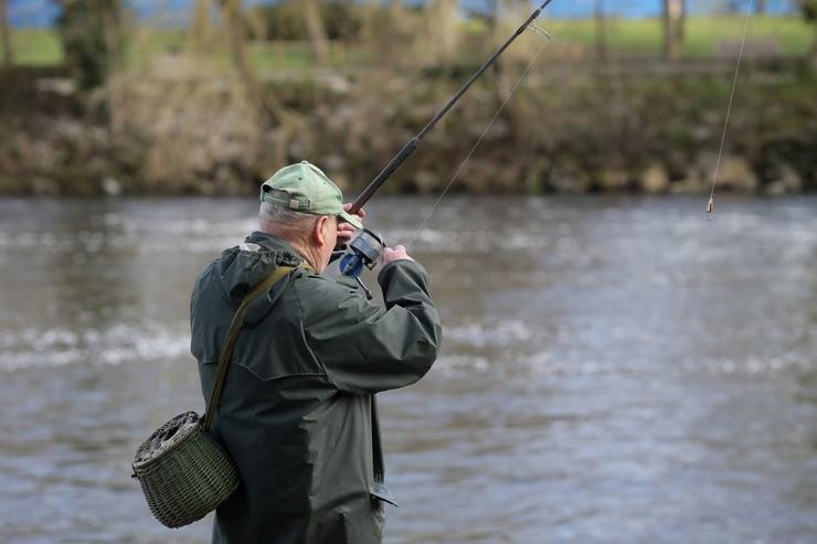 Un pescador lanza a cana no río, durante o primeiro día de tempada de pesca fluvial, a 19 de marzo de 2023, en Rábade 