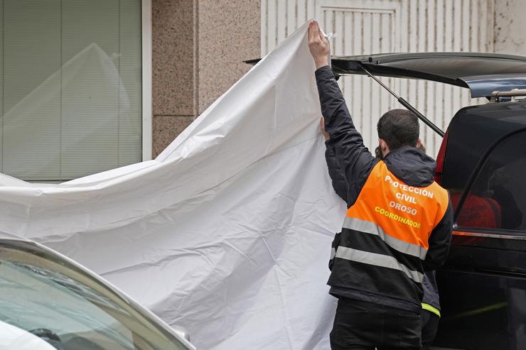 Un axente de Protección Civil tapa cunha lona a zona onde se atoparon os corpos, a 1 de decembro de 2023, en Sigüeiro, Oroso, A Coruña, Galicia (España).. Álvaro Ballesteros - Europa Press 