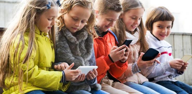 Nenos usando os móbiles no recreo / Getty Images - Arquivo