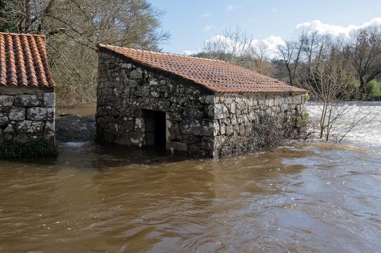 O río Tambre, desbordado ao seu paso polo concello de Oroso, na Coruña 