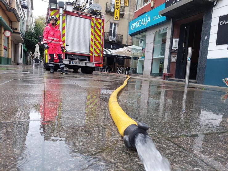 Bombeiros achicando auga tras unha inundación 