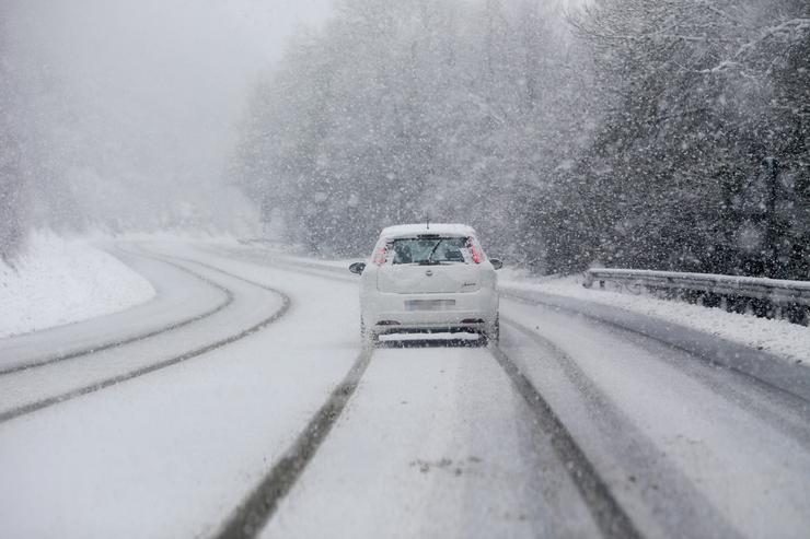 Un coche conduce por unha estrada cuberta de nev / Carlos Castro - Europa Press