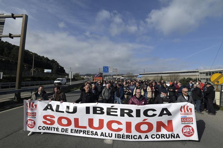 Un grupo de persoas protesta cunha pancarta durante unha concentración fronte á fábrica de Alu Ibérica, o 14 de marzo de 2023, na Coruña.. M. Dylan - Europa Press / Europa Press