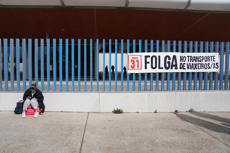 Unha muller á beira dun cartel da folga de transporte, tras unha concentración pola folga do transporte de viaxeiros, na estación de autobuses de Santiago, a 31 de marzo de 2023, en Santiago de Compostela, A Coruña, Galicia (España). A folga, c. Álvaro Ballesteros - Europa Press