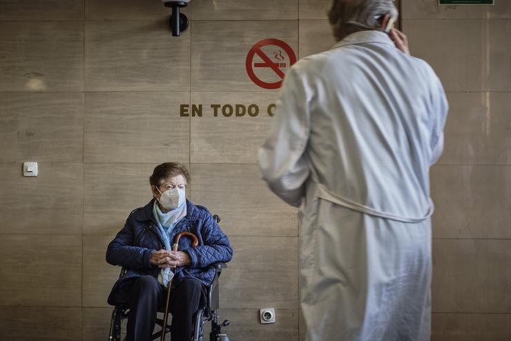 Unha señora espera en cadeira de rodas no Complexo Hospitalario Universitario durante a terceira xornada da folga de médicos galegos 