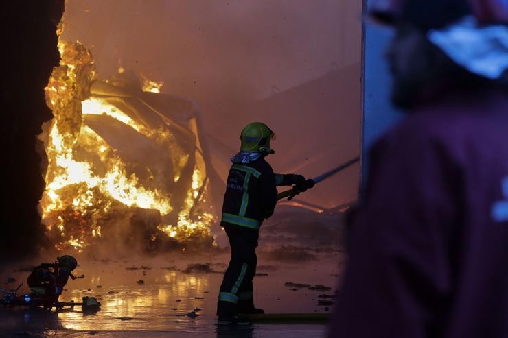 Un equipo de bombeiros traballa durante un incendio 