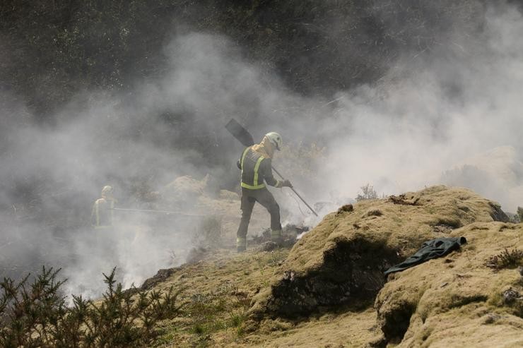 Dous bombeiros forestais traballan para extinguir as chamas nun incendio forestal / Carlos Castro - Europa Press 