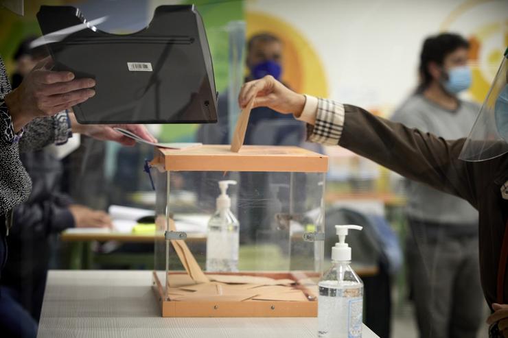 Unha muller vota nunha mesa electoral nas eleccións 