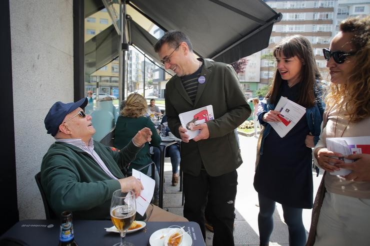 O cofundador de Podemos, Juan Carlos Moedeiro (2d); a candidata de EU-Podemos á Alcaldía de Lugo, Chus Rodríguez (2i), e o número dous da candidatura EU - Podemos á Alcaldía de Lugo, Ximena Cheda (1d), conversan cun señor maior na Praza d. Carlos Castro - Europa Press 