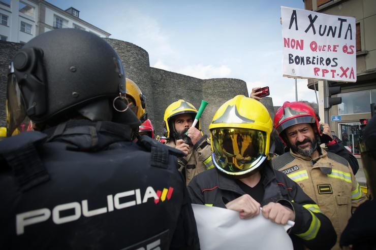 Antidisturbios da Policía durante a protesta de bombeiros de consorcios provinciais ao tentar colocar unha pancarta ante a sede da Xunta / L. Carlos Castro - Europa Press