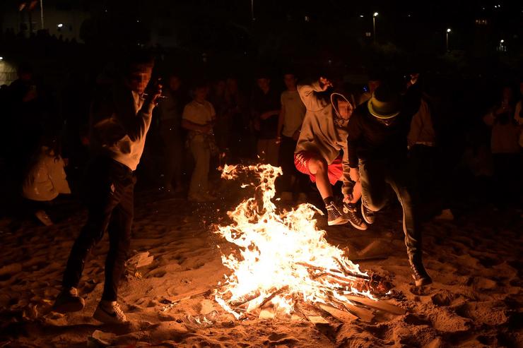 Varios mozos saltan unha fogueira na noite de San Juan, na Coruña 