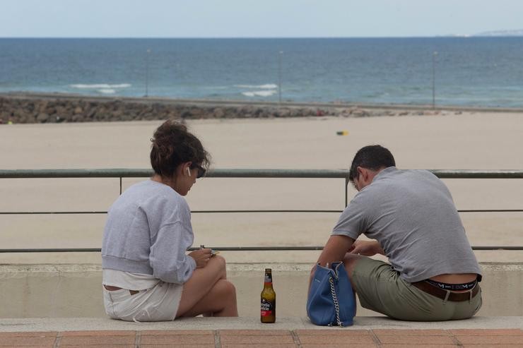 Dúas persoas sentadas fronte ao mar, a 31 de xullo de 2021, na Mariña, Lugo / Carlos Castro - Europa Press 