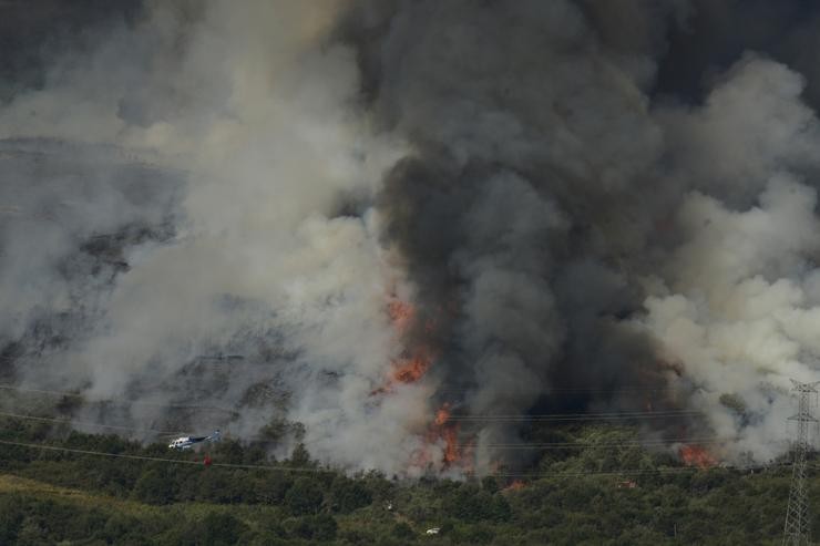 Un helicóptero traballa nos labores extinción nun incendio na Serra do Leboreiro, nos montes do pobo de Senderiz 