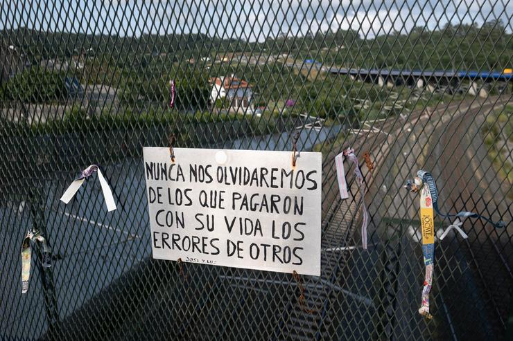 Mensaxe colgada sobre as vías da curva da Grandeira, na parroquia compostelá de Angrois, onde se produxo o accidente do Alvia o 24 de xullo de 2013, no que faleceron 80 persoas / CÉSAR ARXINA