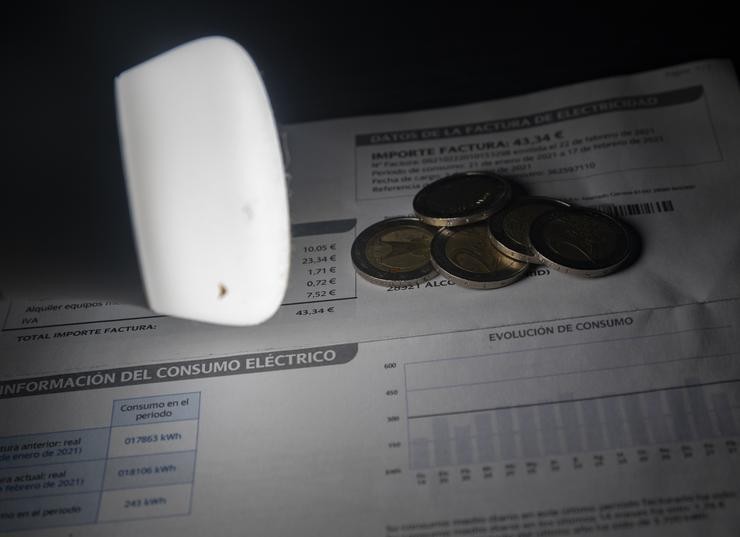 Unha lámpada reflicte o importe dunha factura o día en que o prezo da luz marcou un mínimo por primeira vez en dous meses, a 27 de decembro de 2021 