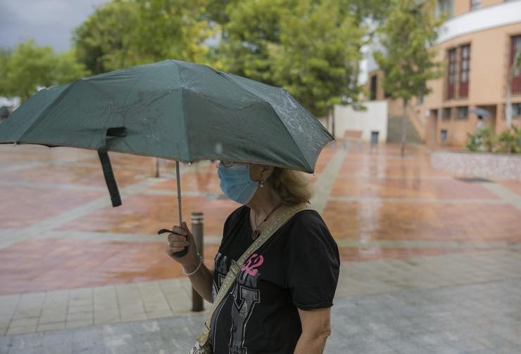 Arquivo - Unha muller protéxese da choiva baixo o seu paraugas. María José López - Europa Press - Arquivo 