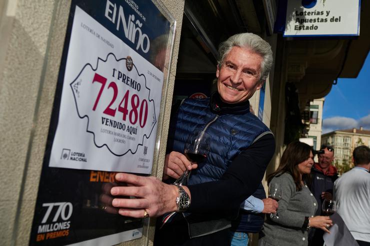O dono da administración número 6 situada na rúa Muro de la Carmen, nº 4, Ángel Alda, celebra que venderon o número 72.480 correspondente ao Primeiro Premio do Sorteo Extraordinario da Lotaría de Nadal 2024, a 22 de decembro de 2024 / Eduardo Sanz
