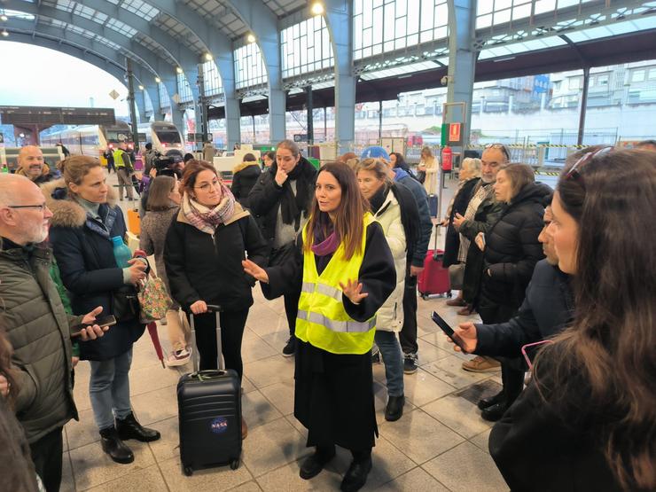 Viaxeiros na estación de tren da Coruña, reciben información tras confirmar que un fallo eléctrico impide a chegada e saída de trens, a 11 de xaneiro de 2024.