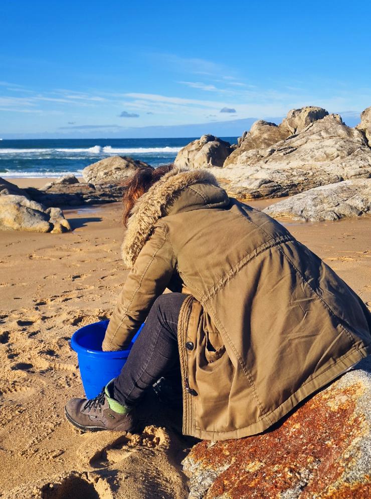 Veciña de Santiago limpando na praia do Espiñeirido, a 11 de xaneiro de 2024 