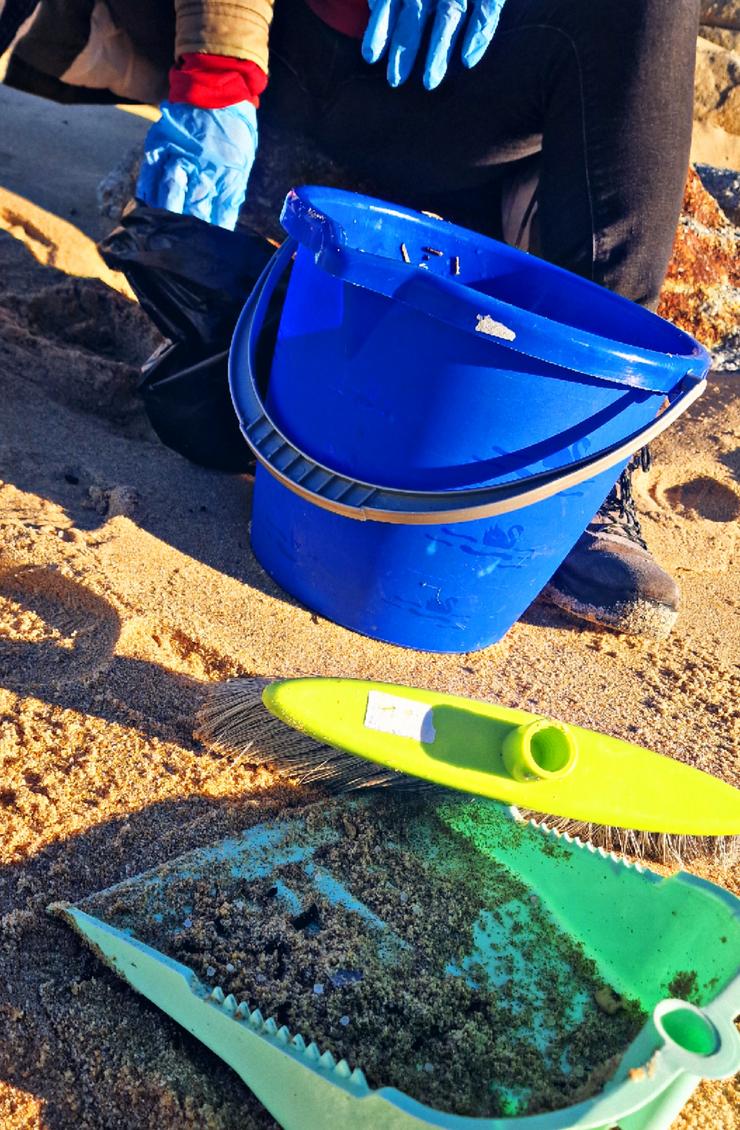 Veciña de Santiago limpando na praia do Espiñeirido, a 11 de xaneiro de 2024 