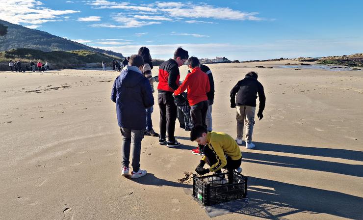 Estudantes do IES Porto do Son colaboran na recollida dos pélets na praia de Cabeiro 