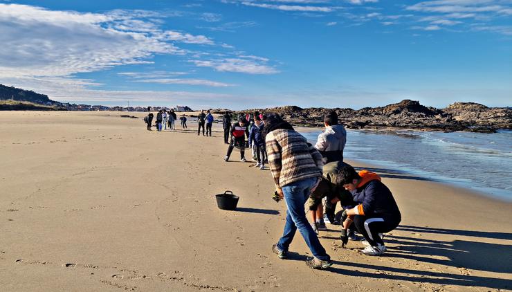 Estudantes do IES Porto do Son colaboran na recollida dos pélets na praia de Cabeiro / GC