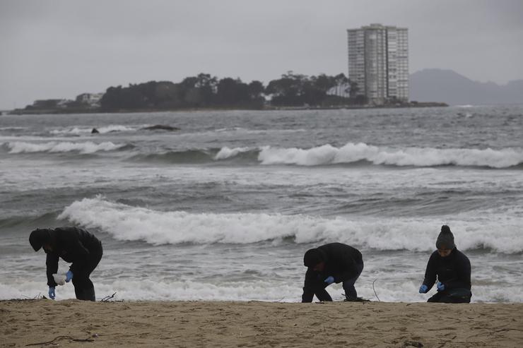 Voluntarios limpan pellets na praia de Samil, a 10 de xaneiro de 2024, en Vigo / Adrián Irago - Arquivo / Europa Press