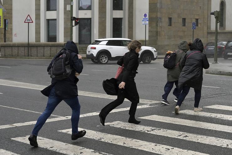 Varias persoas corren baixo a choiva durante a fronte meteorolóxica, a 23 de febreiro de 2024, na Coruña / M. Dylan - Arquivo