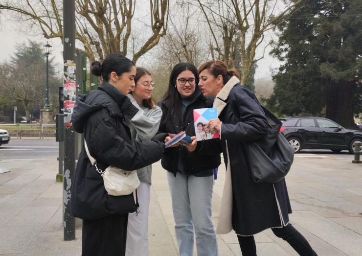 A candidata de Sumar Galicia, Marta Lois, reparte folletos electorais a unhas mozas en Santiago de Compostela / Europa Press