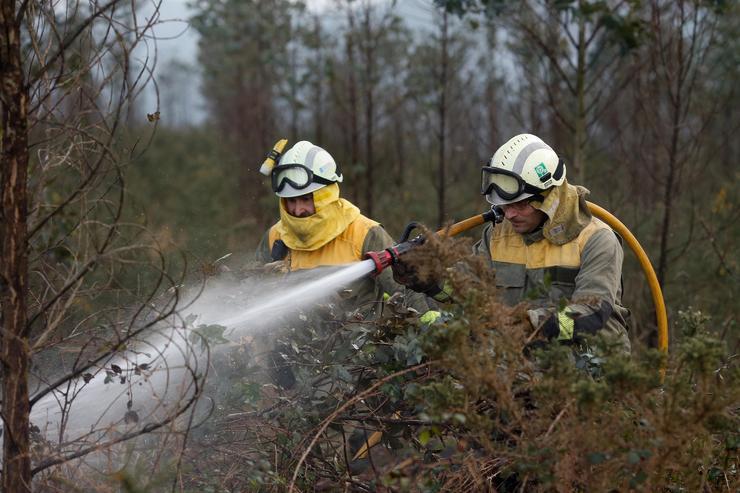 Axentes dos equipos de bombeiros traballan nun incendio 