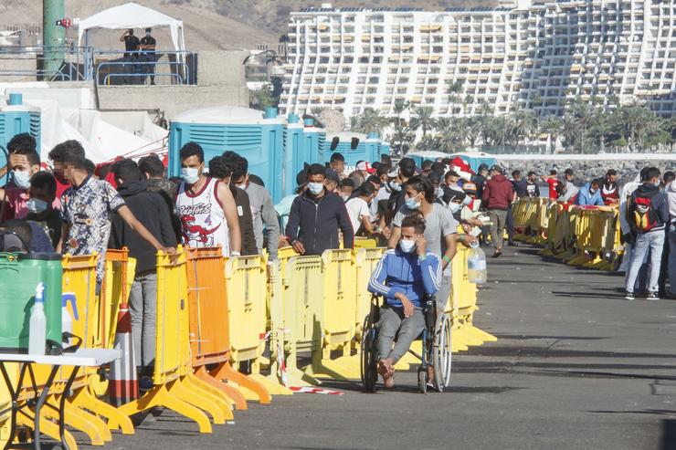 Varios inmigrantes fan cola no Peirao de Arguineguín, en Gran Canaria 