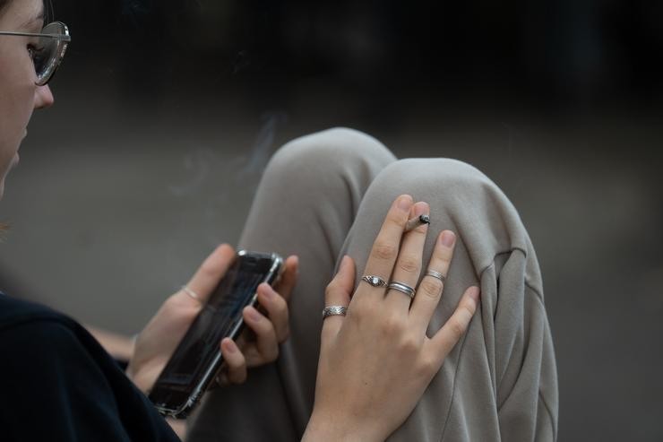 Arquivo - Unha moza fuma e le a súa movil nas inmediacións do colexio Pia Balmes, que a nova normativa do Govern converterá en espazo libre de fume, a 23 de setembro de 2022, en Barcelona, Catalunya (España). A nova normativa consiste en conver. David Zorrakino - Europa Press - Arquivo / Europa Press