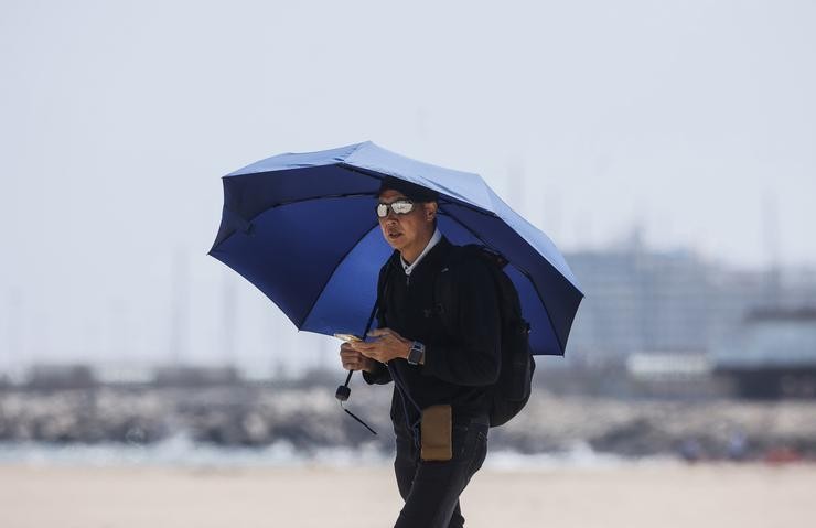 Un home camiña pola praia da Malvarrosa, a 26 de abril de 2023, en Valencia, Comunidade Valenciana (España). As temperaturas na Comunitat Valenciana alcanzarán esta semana valores propios de verán, con máximas que poderían superar os. Rober Solsona - Europa Press - Arquivo