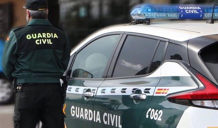 Un axente da Garda Civil xunto a un vehículo oficial. Imaxe de arquivo 