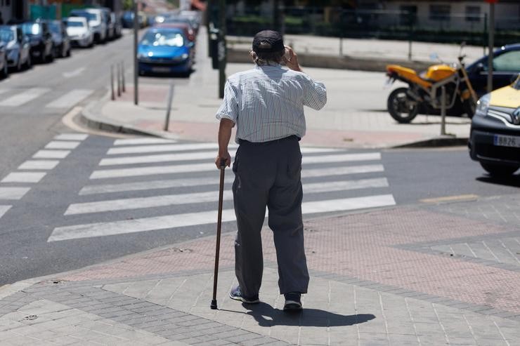Un home maior pasea apoiándose nun bastón 